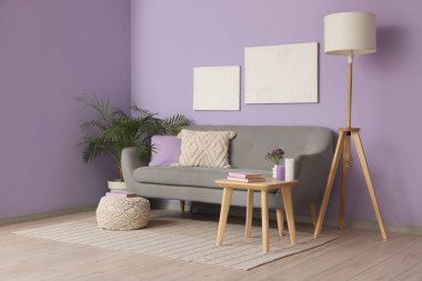 Rahat kanepe, sehpa, resimler ve lamba oturma odasının içinde.