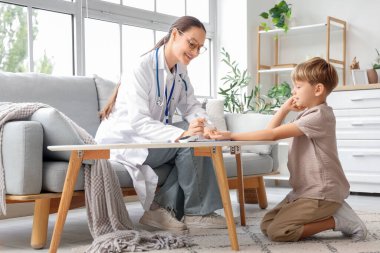 Doktoru olan küçük şeker hastası çocuk evde tükenmez kalem kullanıyor.