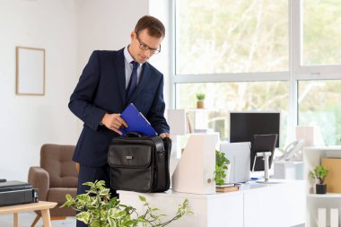 Ofisteki evrak çantasından pano alan yakışıklı bir iş adamı.