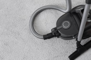 Halıda modern elektrikli süpürge, üst manzara.