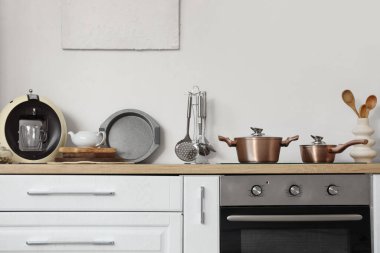 Utensiller tezgahta, soba ve fırın hafif mutfakta.