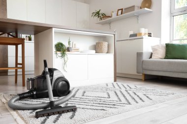 Elektrik süpürgesi, masa ve tezgahlı mutfağın içi.