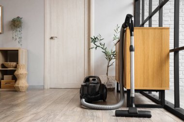 Odadaki klozetin yanındaki elektrikli süpürge.