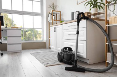 Ofis içi masaların yanındaki elektrikli süpürge.