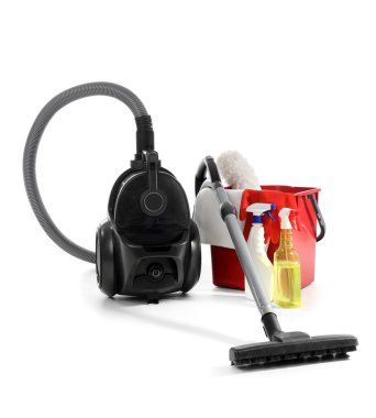 Beyaz arka planda temizlik malzemeleri olan modern elektrikli süpürge.