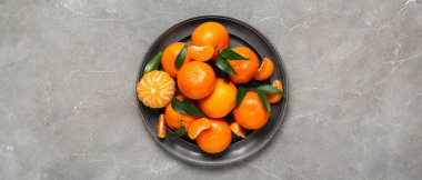Gri arkaplanda tatlı mandalina tabakası, üst görünüm