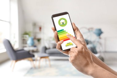 Odada enerji verimliliği dereceli cep telefonu tutan eller ekranda