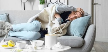 Evdeki sıcaklığı ölçen genç bir adam.