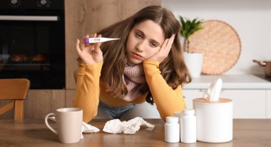 Mutfakta termometresi olan hasta genç bir kadın.