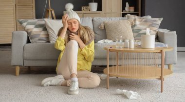 Evde başı ağrıyan genç bir kadın.