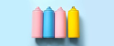 Açık mavi arka planda farklı sprey kutuları, üst görünüm