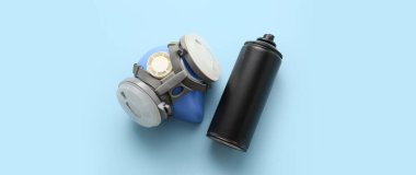 Spray can and respirator on light blue background, top view clipart