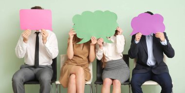 Yeşil arka planda boş konuşma baloncukları olan bir grup iş adamı