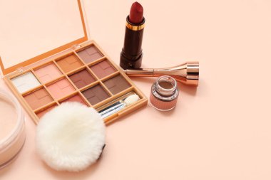 Göz kalemi, toz ve ruj ile bej arka planda göz falı paleti