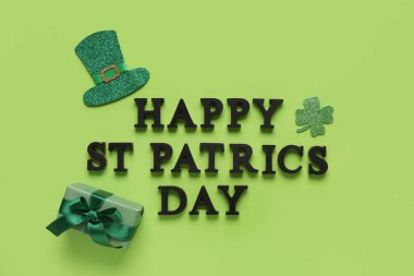 Yeşil arkaplanda hediye kutusu ve dekorla Aziz Patrik Günü kutlu olsun.
