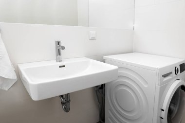 Banyoda beyaz lavabo ve çamaşır makinesi