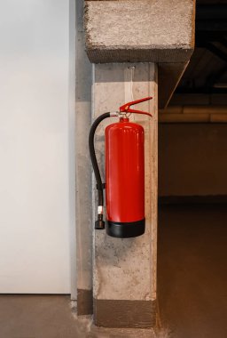 Yeraltı otoparkındaki duvarda asılı yangın söndürücü.