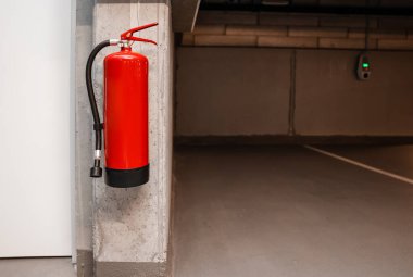 Yeraltı otoparkındaki duvarda asılı yangın söndürücü.