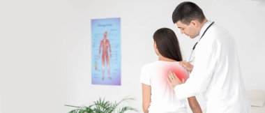 Erkek doktor klinikteki genç kadının duruşunu kontrol ediyor.