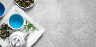 Gri zemin üzerinde kelebek bezelye çiçeği çayı ile kompozisyon metin için boşluk, üst görünüm