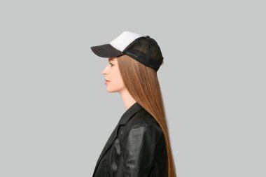 Gri arka planda şık şapkalı güzel bir kadın.