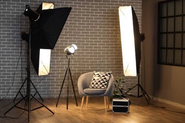 Profesyonel ekipman ve koltuk ile aydınlatılmış fotoğraf stüdyosunun içi