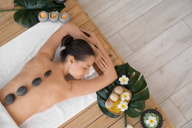 Taşları olan genç bir kadın kaplıcada dinleniyor.