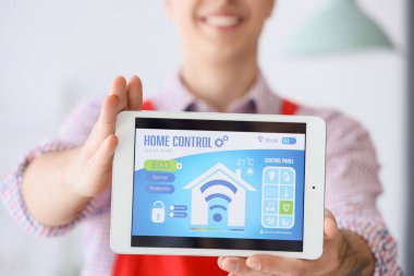 Evde alarm sistemi yüklü tablet gösteren erkek işçi, yakın plan.