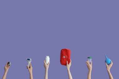 Ellerinde lavman, ilk yardım çantası, haplar, glukometre ve termometre olan leylak arkaplan.