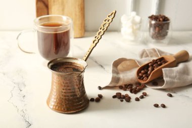 Bir fincan kahve ve sıcak kahve. Işık masasında.