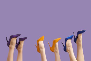 Leylak arka planında farklı topuklu kadın bacakları.