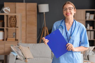 Gözlüklü genç bayan tıp öğrencisi. Evinde pano var.