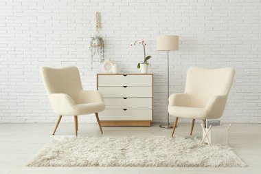 Koltuklar, çekmeceler ve kabarık halı oturma odasında.