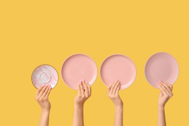 Sarı arkaplanda boş tabakları tutan eller