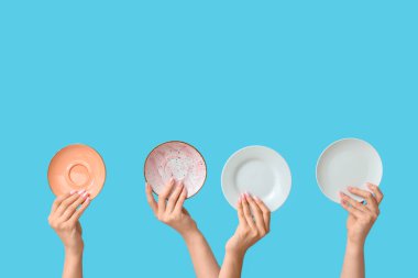 Mavi arkaplanda boş tabakları tutan eller