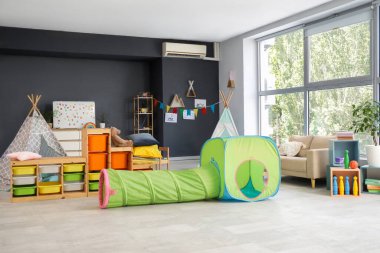 Oyun tüneli ve çadırları olan bir anaokulu.