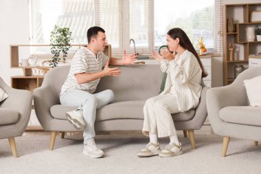 Kızgın genç çift evde kavga ediyor.