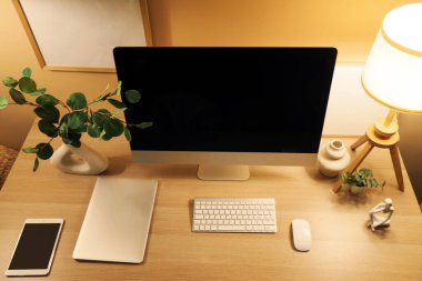 Geceleri modern bilgisayar, lamba ve tabletli işyeri