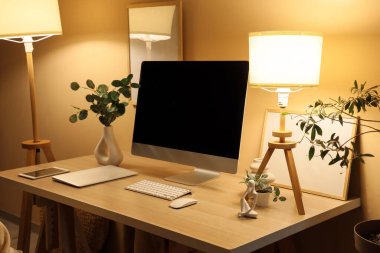Geceleri modern bilgisayar, lamba ve tabletli işyeri