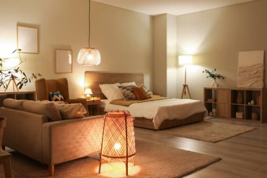 Rahat koltuğu, kanepesi ve yatağı olan şık bir yatak odası.