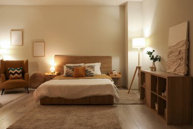 Yatak odasının şık bir iç mekanı. Akşamları rahat bir koltuk ve yatak.