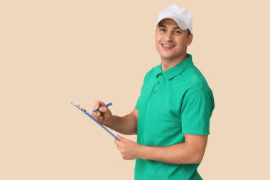 Teslimatçı bej arka planda panoya yazı yazıyor.