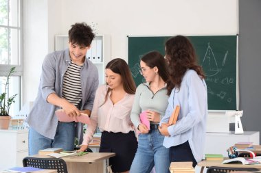 Sınıfta kitap okuyan bir grup genç öğrenci.