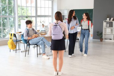 Sınıfta sırt çantalı genç bir kız öğrenci.