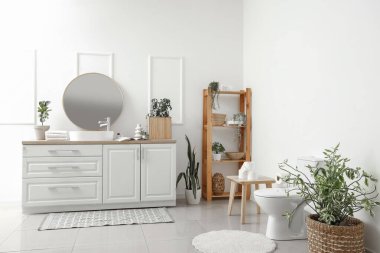 Modern klozet, lavabolu tezgah, ayna ve raflı tuvalet.