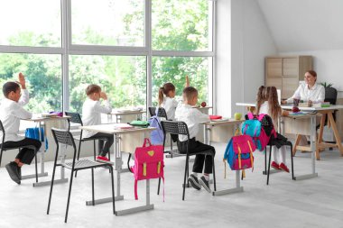 Sınıfta ders alan küçük öğrenciler, arka manzara...