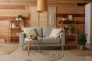 Oturma odasında kanepe, masa ve raf üniteleri var.