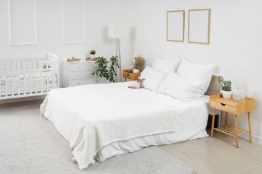 Küçük çocukların yatak odasının içinde, rahat yatağında beşiği ve pelüş oyuncağı var.