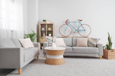 Koltuklar, kahve masası, raf ünitesi ve bisiklet oturma odasının içinde.