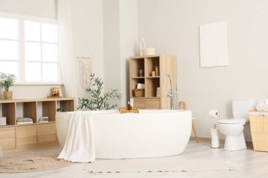 Banyonun içinde havlu, klozet ve raf üniteleri olan küvet.